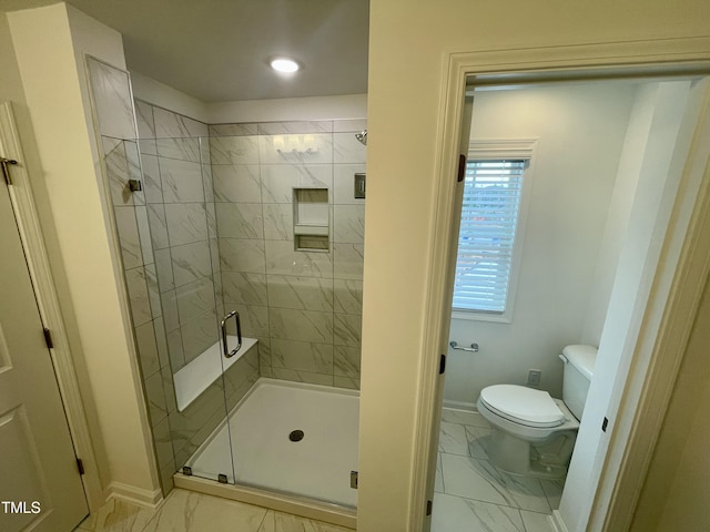 bathroom with a shower with shower door and toilet