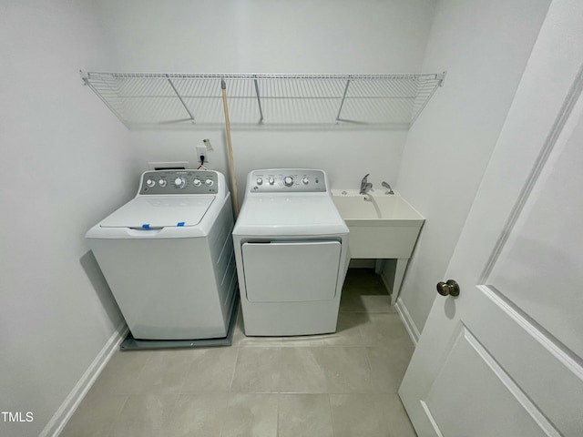 clothes washing area featuring light tile patterned flooring, sink, and washing machine and clothes dryer