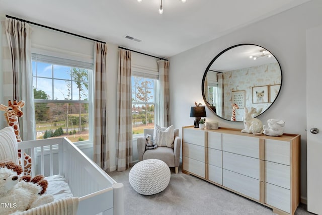 carpeted bedroom featuring a nursery area