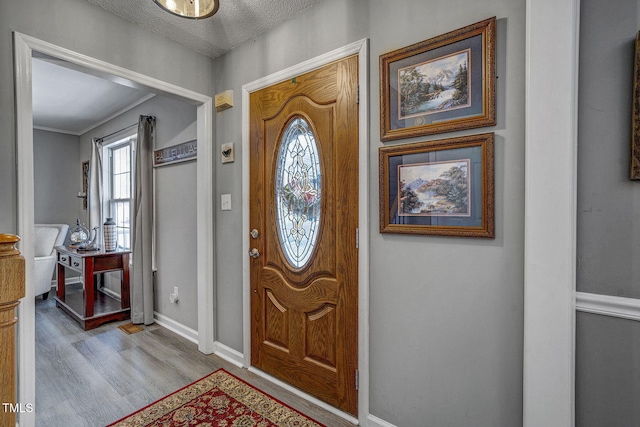 foyer entrance featuring light wood-type flooring and a textured ceiling