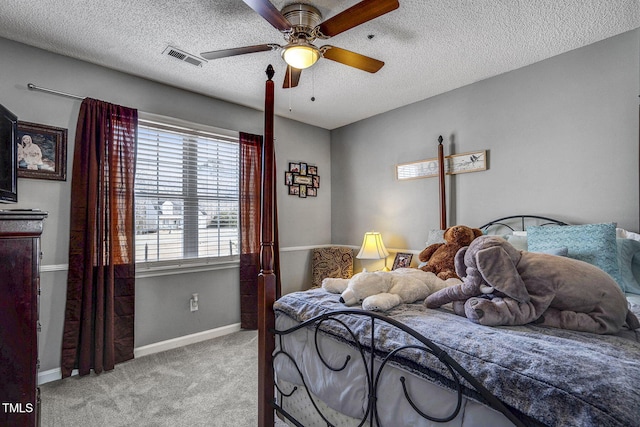 bedroom featuring ceiling fan, light colored carpet, and a textured ceiling