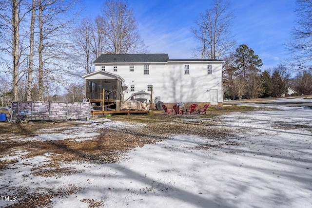 snow covered property featuring a sunroom and a deck