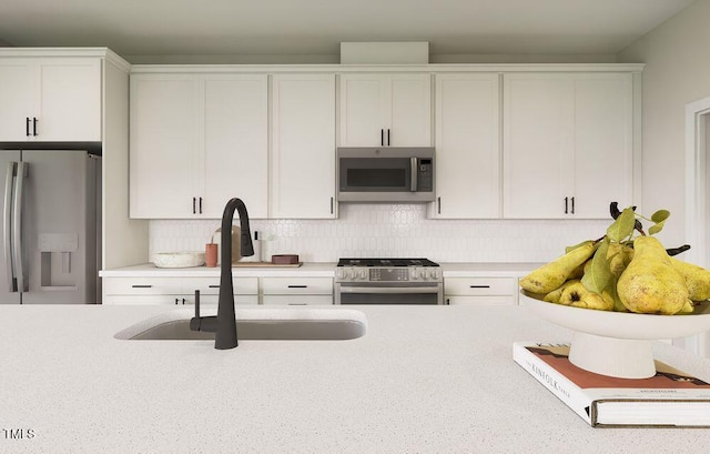 kitchen featuring tasteful backsplash, sink, stainless steel appliances, and white cabinetry