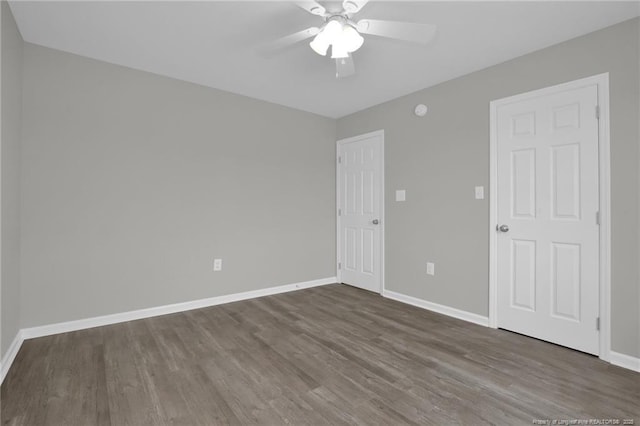 unfurnished room featuring dark wood-type flooring and ceiling fan