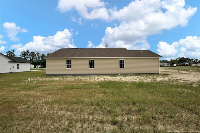 rear view of property featuring a yard