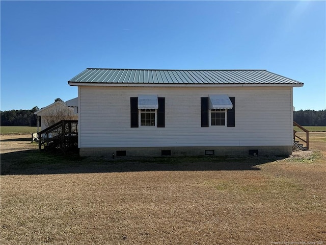 view of side of home with a yard