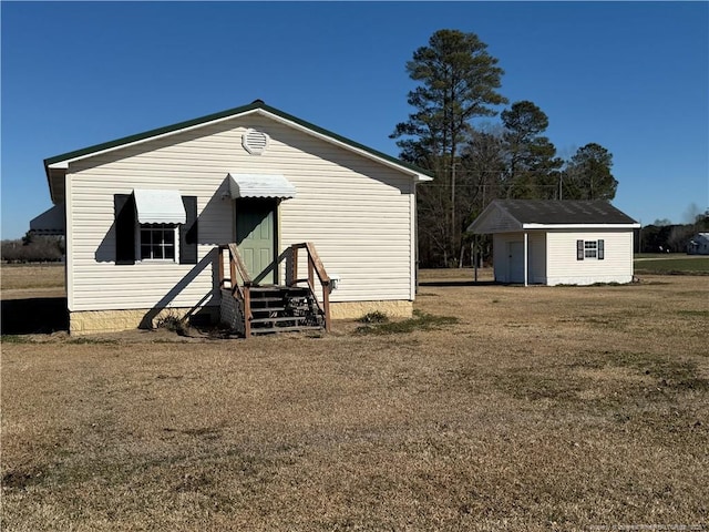 view of front facade featuring a front yard and an outdoor structure