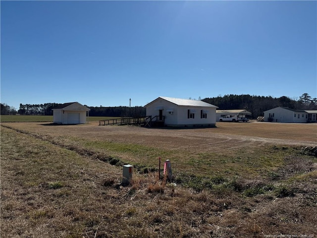 view of yard with an outbuilding, a rural view, and a garage