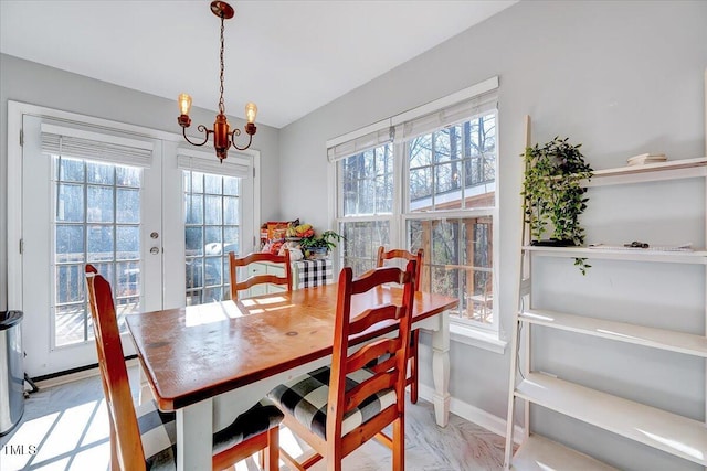 dining space with a chandelier and french doors