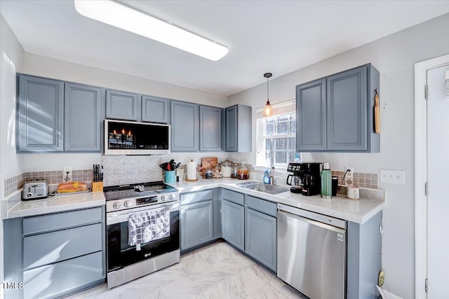 kitchen featuring sink, stainless steel appliances, and pendant lighting