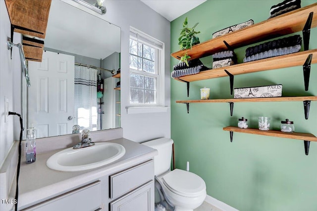 bathroom featuring curtained shower, toilet, and vanity