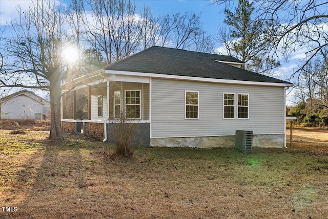 view of home's exterior with central AC, a sunroom, and a lawn