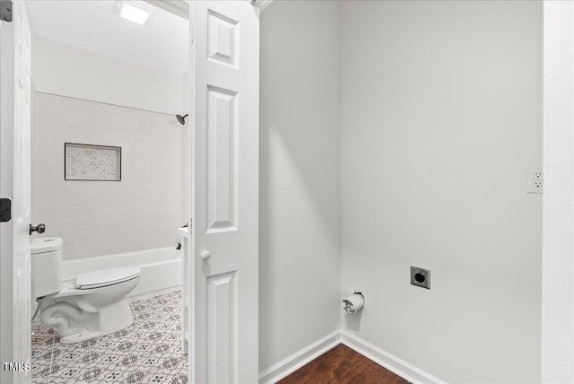 bathroom with tiled shower / bath combo and toilet