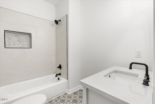 full bathroom featuring tiled shower / bath, vanity, and toilet