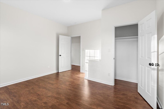 unfurnished bedroom with dark hardwood / wood-style floors and a closet