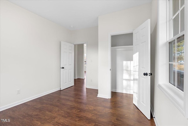 unfurnished bedroom featuring dark hardwood / wood-style flooring and a closet