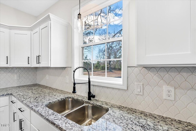 kitchen with white cabinetry, sink, and hanging light fixtures