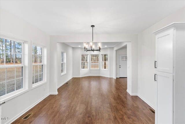 unfurnished dining area featuring dark hardwood / wood-style flooring and a chandelier