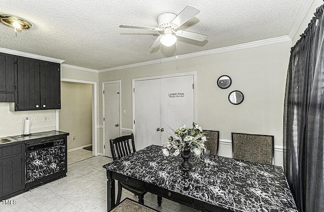 dining area featuring ornamental molding, ceiling fan, and a textured ceiling