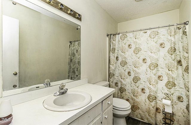 bathroom featuring vanity, toilet, and a textured ceiling