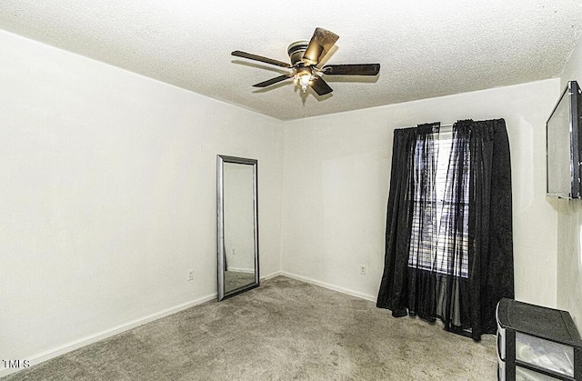 spare room featuring ceiling fan, light carpet, and a textured ceiling