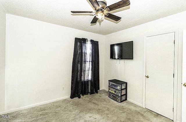 unfurnished bedroom featuring ceiling fan, light colored carpet, and a textured ceiling