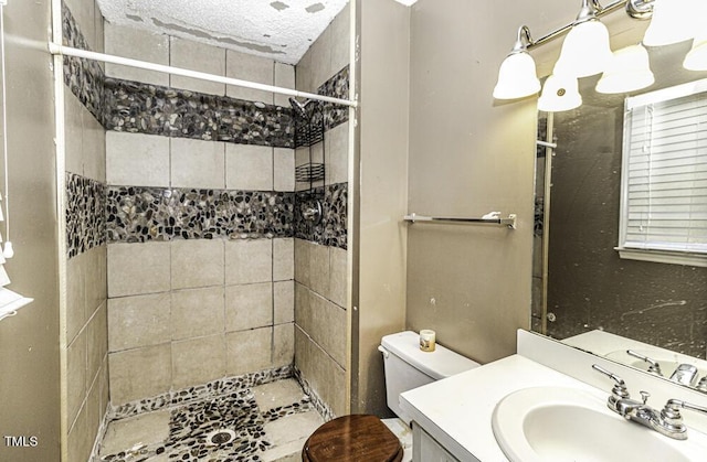 bathroom with vanity, toilet, and tiled shower