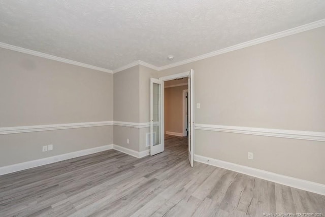 unfurnished room with light hardwood / wood-style floors, a textured ceiling, and ornamental molding