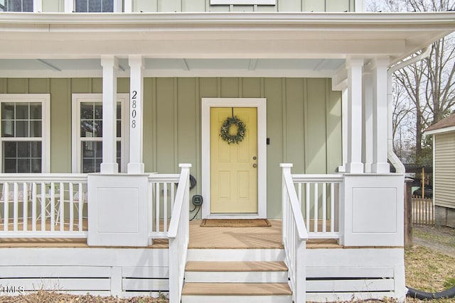 view of exterior entry featuring a porch and board and batten siding