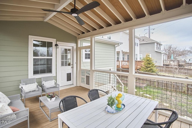 sunroom with vaulted ceiling with beams and a ceiling fan