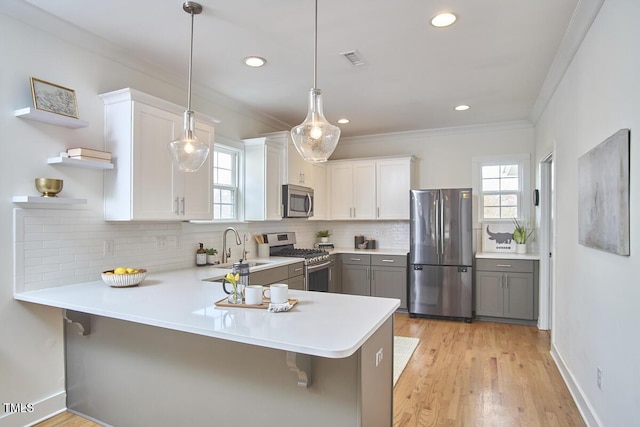 kitchen featuring stainless steel appliances, ornamental molding, open shelves, and light countertops