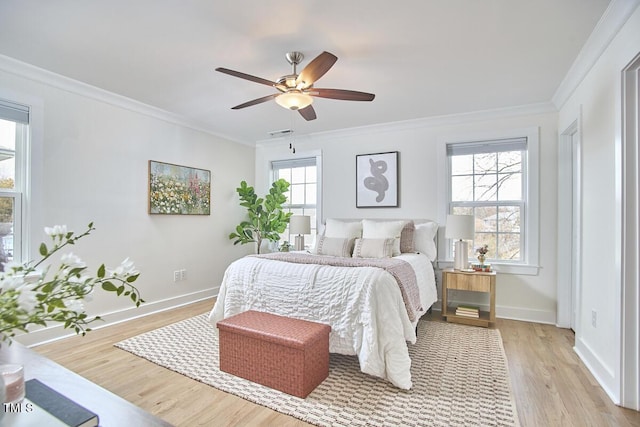 bedroom featuring light wood finished floors, multiple windows, and ornamental molding