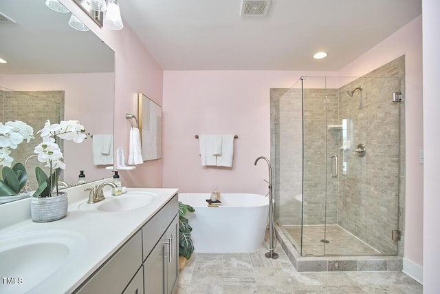 bathroom with a freestanding tub, a shower stall, visible vents, and a sink