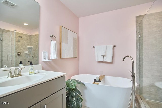 full bathroom featuring a stall shower, a soaking tub, visible vents, and vanity