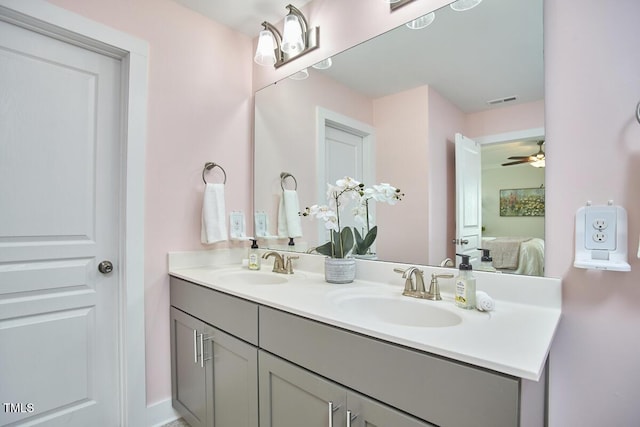 ensuite bathroom with ensuite bathroom, double vanity, a sink, and visible vents