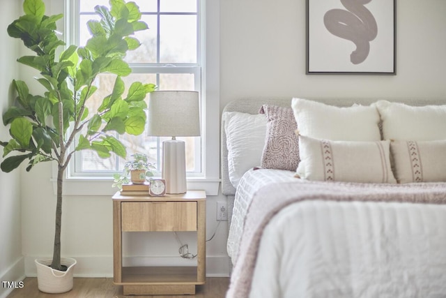 bedroom featuring wood finished floors and baseboards