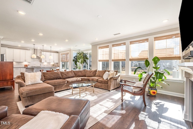 living room with ornamental molding, sink, and light hardwood / wood-style flooring