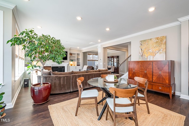 dining room with ornamental molding, built in features, and dark hardwood / wood-style flooring