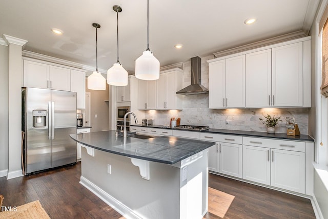 kitchen featuring a kitchen island with sink, wall chimney range hood, white cabinetry, and stainless steel appliances