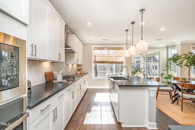 kitchen with white cabinetry, appliances with stainless steel finishes, decorative light fixtures, and sink