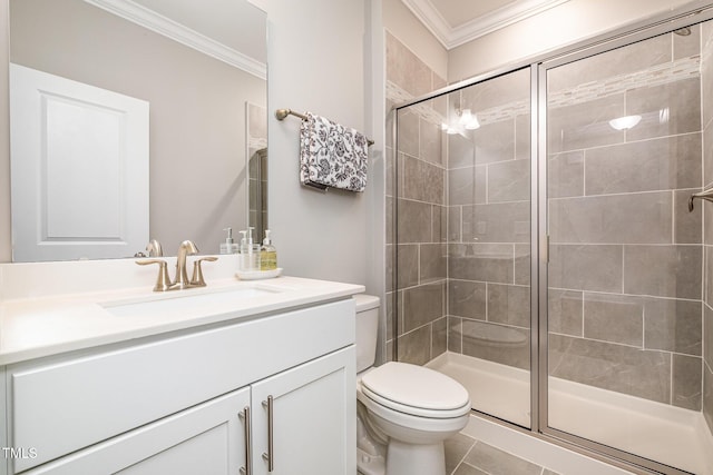 bathroom with tile patterned floors, toilet, crown molding, vanity, and a shower with door