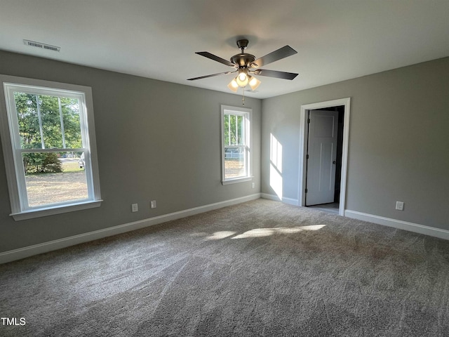 carpeted spare room with ceiling fan and a wealth of natural light