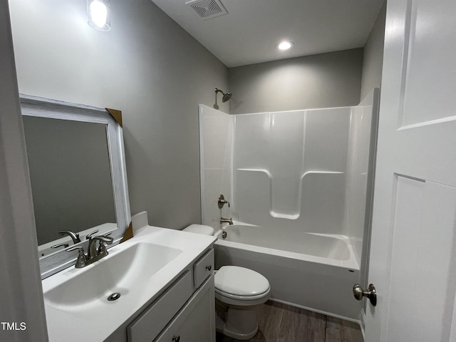 full bathroom with toilet, vanity,  shower combination, and hardwood / wood-style floors