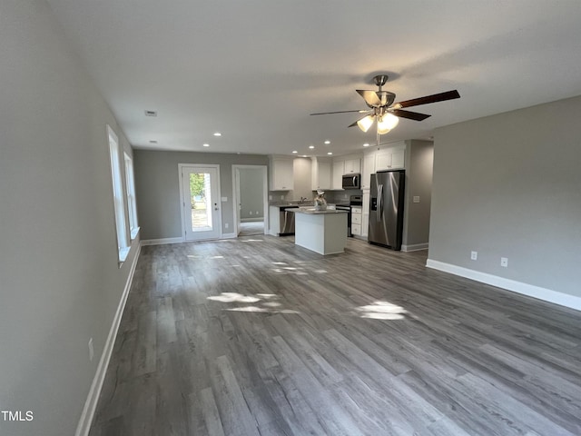 unfurnished living room featuring ceiling fan and hardwood / wood-style flooring