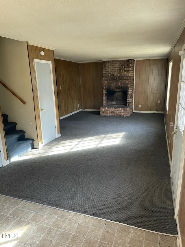 unfurnished living room with wooden walls, light carpet, and a fireplace