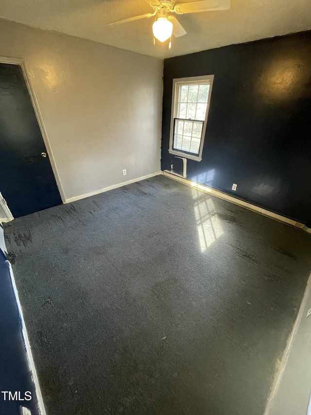 carpeted spare room featuring ceiling fan