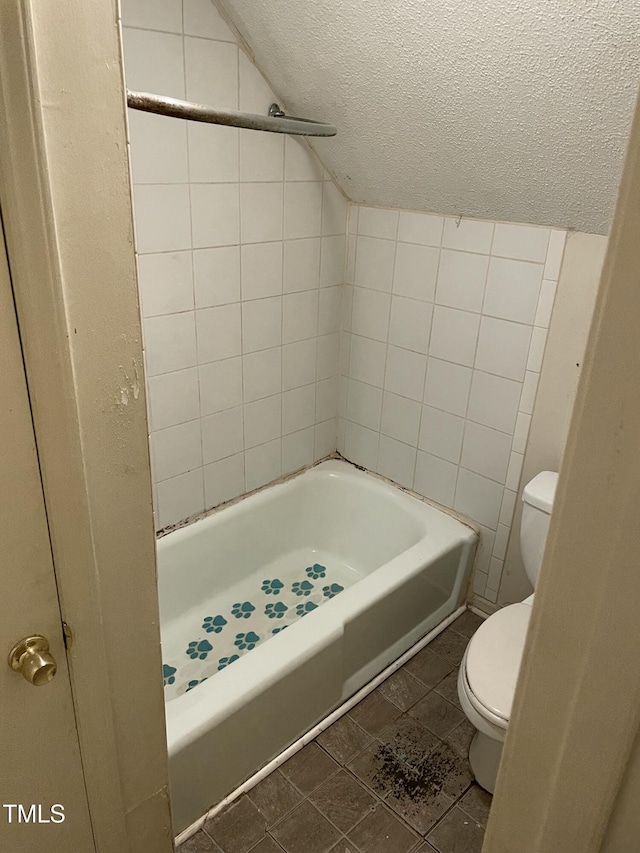 bathroom with lofted ceiling, a textured ceiling, and toilet