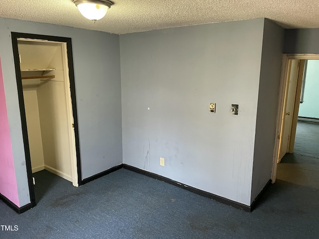 unfurnished bedroom featuring a baseboard radiator, a closet, a textured ceiling, and dark colored carpet