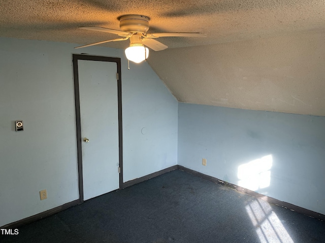 additional living space featuring ceiling fan, vaulted ceiling, and a textured ceiling