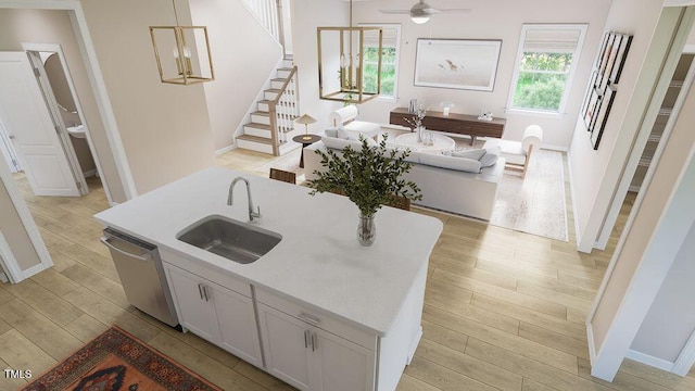 kitchen featuring white cabinetry, ceiling fan, decorative light fixtures, stainless steel dishwasher, and sink